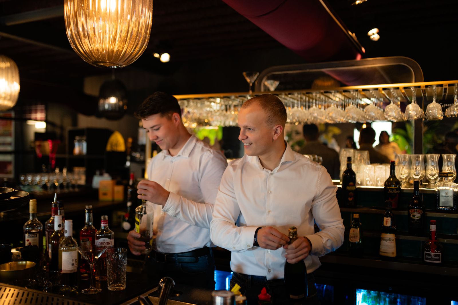 Twee Sparkers aan het werk achter de bar met flessen